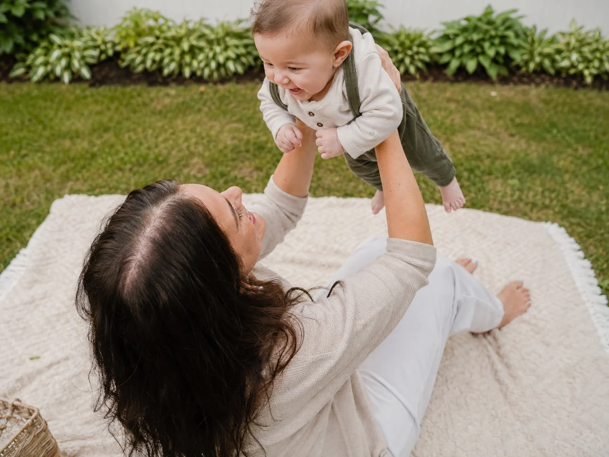 Kayla holding Owen up on a blanket, photographed from above